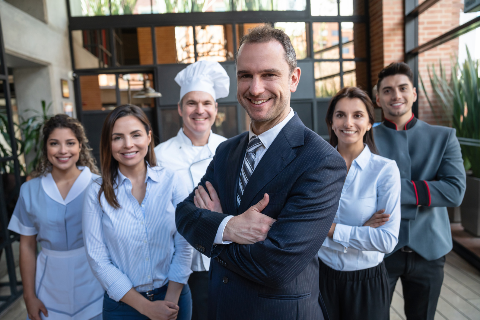 Portrait of luxury hotel staff facing camera smiling lead by hotel manager